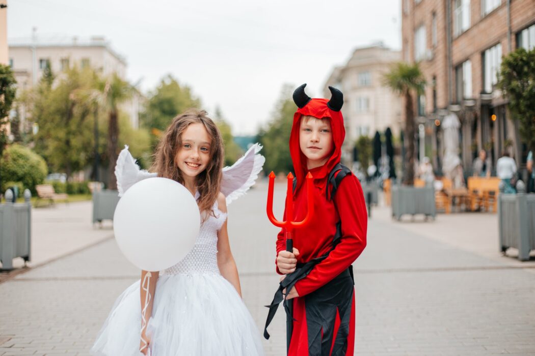 Kids dressed as an angel and a demon 