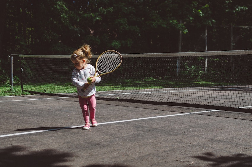 little girl playing tennis